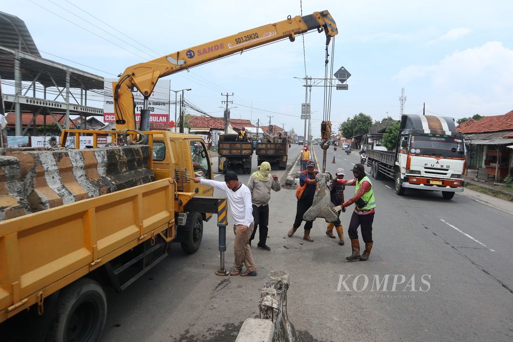 Petugas menutup penggalan jalan atau <i>U-turn </i>dengan beton menjelang Pasar Tegalgubug, Kabupaten Cirebon, Jawa Barat, Senin (18/4/2022). Pemasangan tersebut untuk mencegah kemacetan di sekitar pasar saat arus mudik Lebaran 2022.