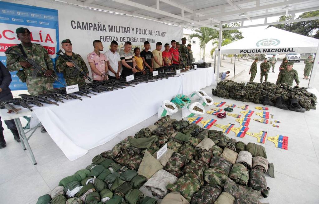 Sejumlah tentara menjaga anggota FARC yang berhasil ditangkap. Mereka dan sejumlah perlengkapan mereka ditampilkan dalam jumpa pers di Tumaco, di bagian selatan Kolombia pada 9 Desember 2022 lalu.
