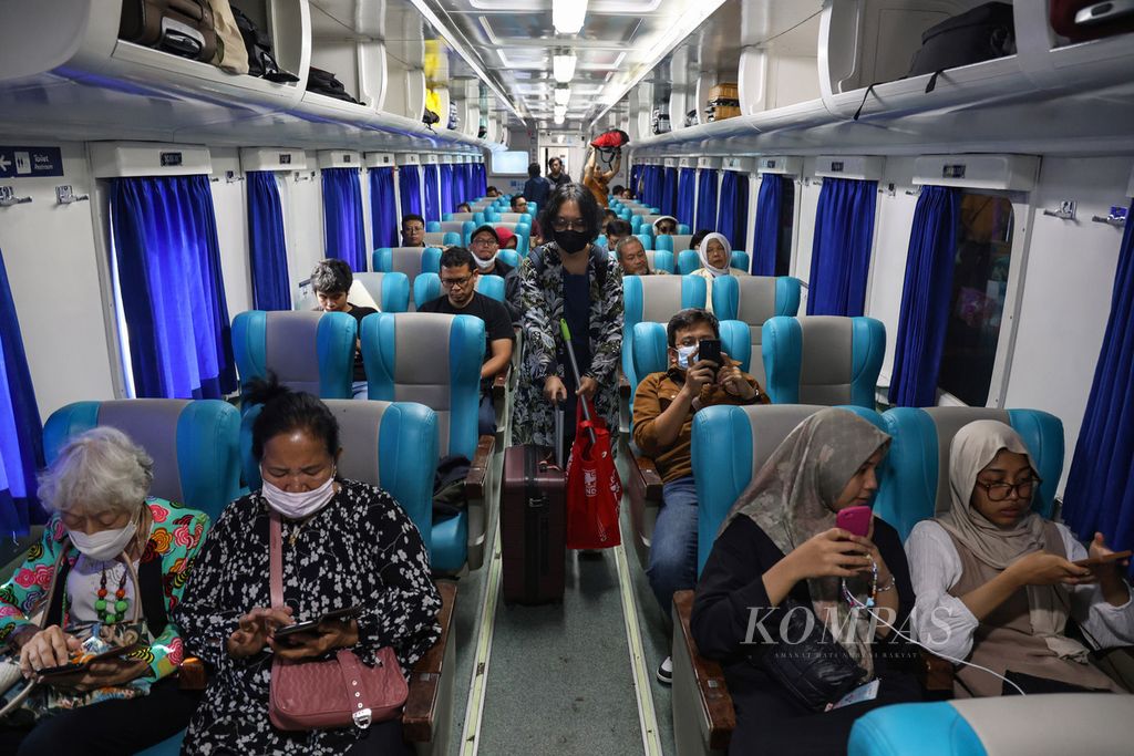 Warga berjalan di dalam kereta saat berhenti di Stasiun Gambir, Jakarta, Kamis (21/12/2023). Lebih dari 14 ribu warga meninggalkan Jakarta melalui Stasiun Gambir pada 21 Desember 2023. Puncak arus mudik pada masa libur Natal dan Tahun Baru 2024 diprediksi terjadi pada 22-23 Desember 2023. KOMPAS/FAKHRI FADLURROHMAN (FAK) 21-12-2023