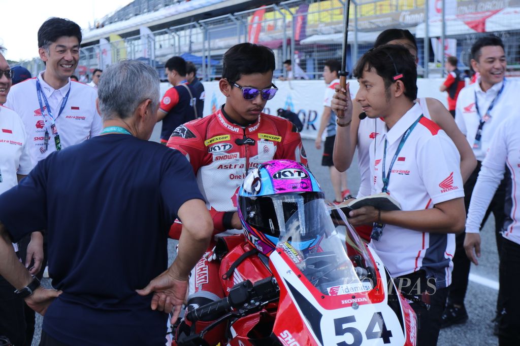 Pebalap tim Astra Honda Racing, Veda Ega Pratama, mendapat arahan dari pelatihnya menjelang start balapan pertama kelas Asia Production 250 dalam seri terakhir Asia Road Racing Championship di Sirkuit Internasional Chang, Buriram, Thailand, Sabtu (2/12/2023).