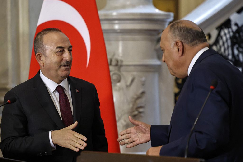 Menteri Luar Negeri Turki Mevlut Cavusoglu (kiri) mengulurkan tangan hendak menjabat tangan Menlu Mesir Sameh Shoukry saat keduanya bertemu di Kairo, Mesir, Sabtu (18/3/2023). Turki dan Mesir, yang memiliki hubungan tidak baik selama 10 tahun terakhir, memutuskan memulai menormalisasi hubungannya sejak 2021. 