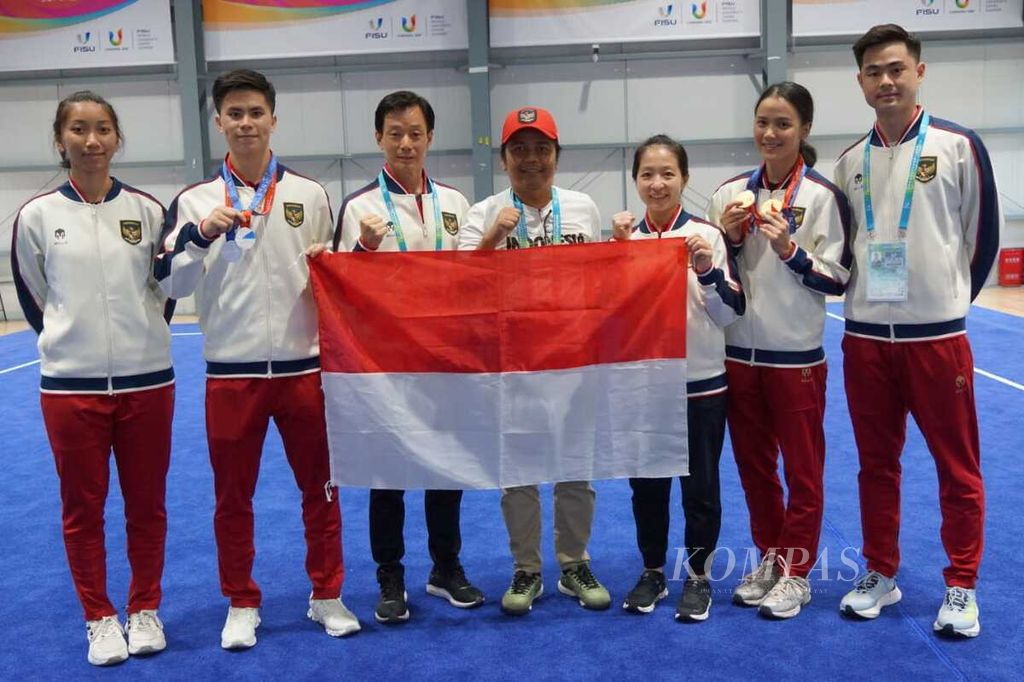 Ketua Kontingen Indonesia Del Asri (keempat dari kiri) berfoto dengan tim wushu <i>taolu</i> dan medali yang diraih di Chengbei Gymnasium, Chengdu, China, Minggu (27/7/2023). Mereka tengah mengikuti Universiade Chengdu 2021.