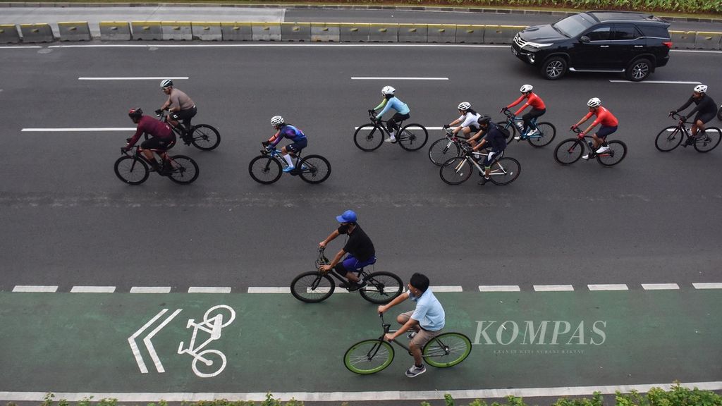 Para pengguna sepeda balap atau <i>road bike</i> melaju di luar jalur sepeda yang telah disediakan di Jalan Jenderal Sudirman, Jakarta, Minggu (6/6/2021). 