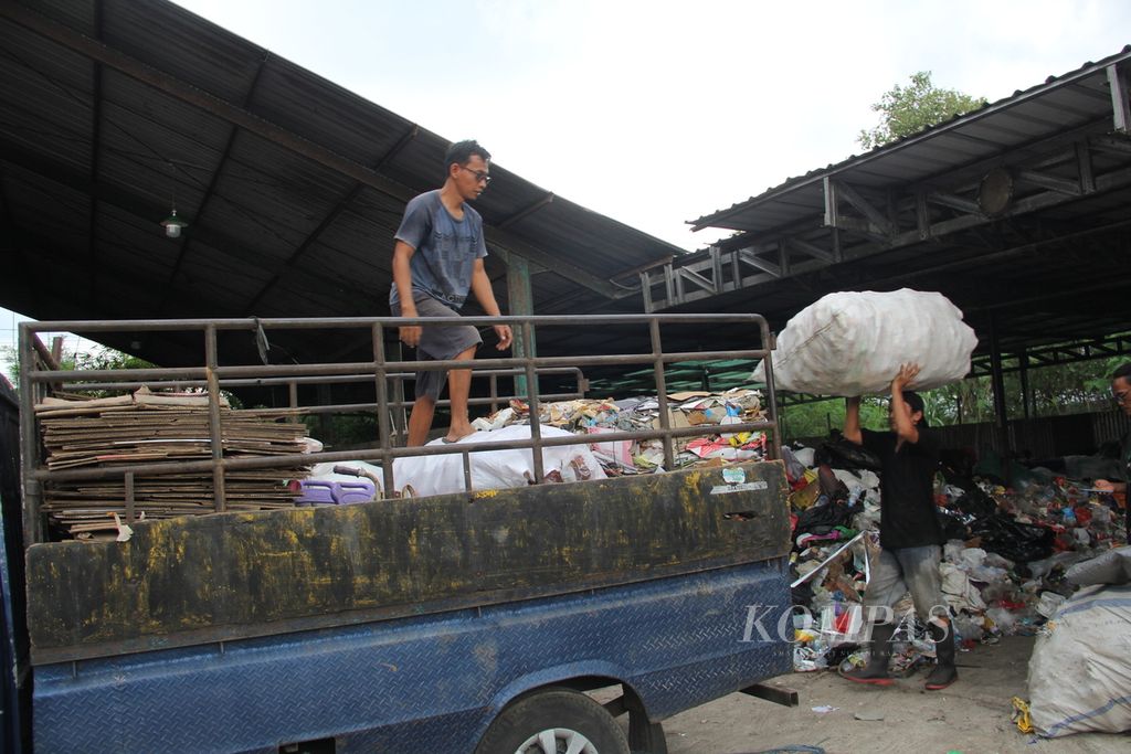 Pekerja mengambil sampah anorganik yang telah dipilah di tempat penampungan sampah milik Kelompok Usaha Pengelolaan Sampah (KUPAS) Desa Panggungharjo, Kabupaten Bantul, DIY, Kamis (17/2/2022).