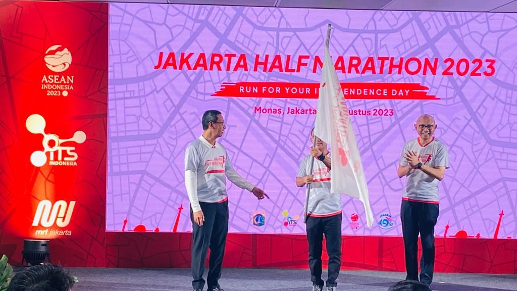 Penjabat (PJ) Gubernur DKI Jakarta Heru Budi Hartono (kiri) bersama Direktur Utama PT MRT Jakarta (Perseroda) Tuhiyat (tengah membawa bendera) dan Presiden ITS William P Sabandar (kanan) meluncurklan Jakarta Half Marathon 2023 di Stasiun MRT ASEAN, Kamis (25/5/2023). 