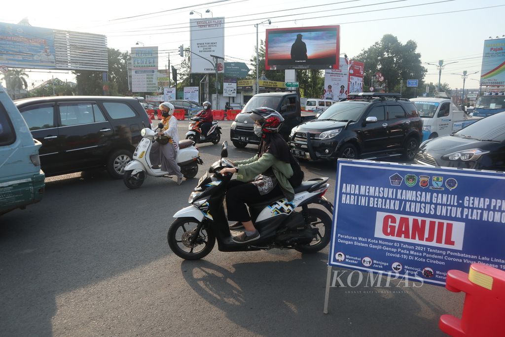 Kendaraan melintasi penjagaan sistem ganjil genap di Jalan Cipto Mangunkusumo, Kota Cirebon, Jawa Barat, Senin (16/8/2021).