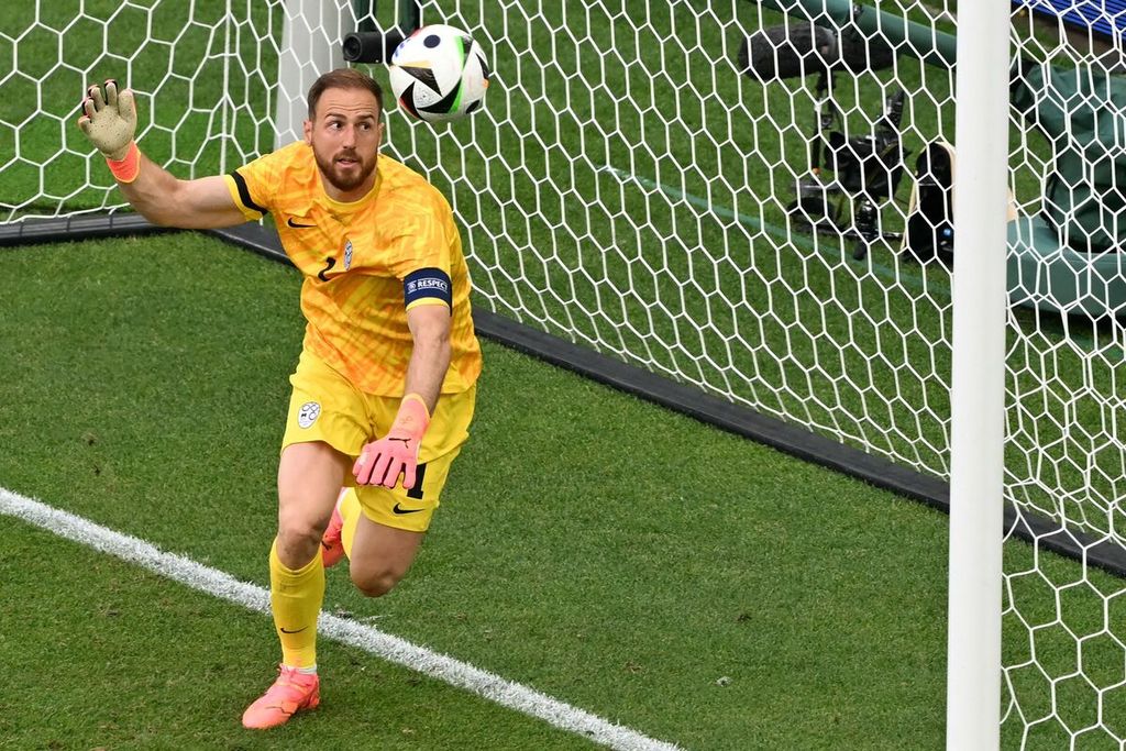 Kiper Slovenia Jan Oblak berusaha membendung bola yang mengarah ke gawangnya saat laga Grup C Piala Eropa 2024 melawan Denmark di Stuttgart, Jerman, 16 Juni 2024. Oblak kembali diandalkan saat Slovenia menghadapi Serbia, Kamis (20/6/2024).