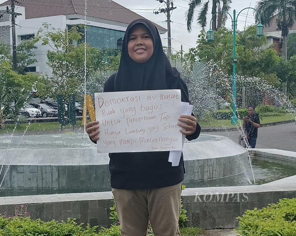 Seorang mahasiswa Universitas Muhammadiyah Yogyakarta (UMY) mengangkat kertas dengan pernyataannya tentang demokrasi, Sabtu (3/2/2024). Pernyataan itu dibuat dan diangkatnya bersamaan dengan penyampaian pesan kebangsaan dari sivitas akademika UMY.
