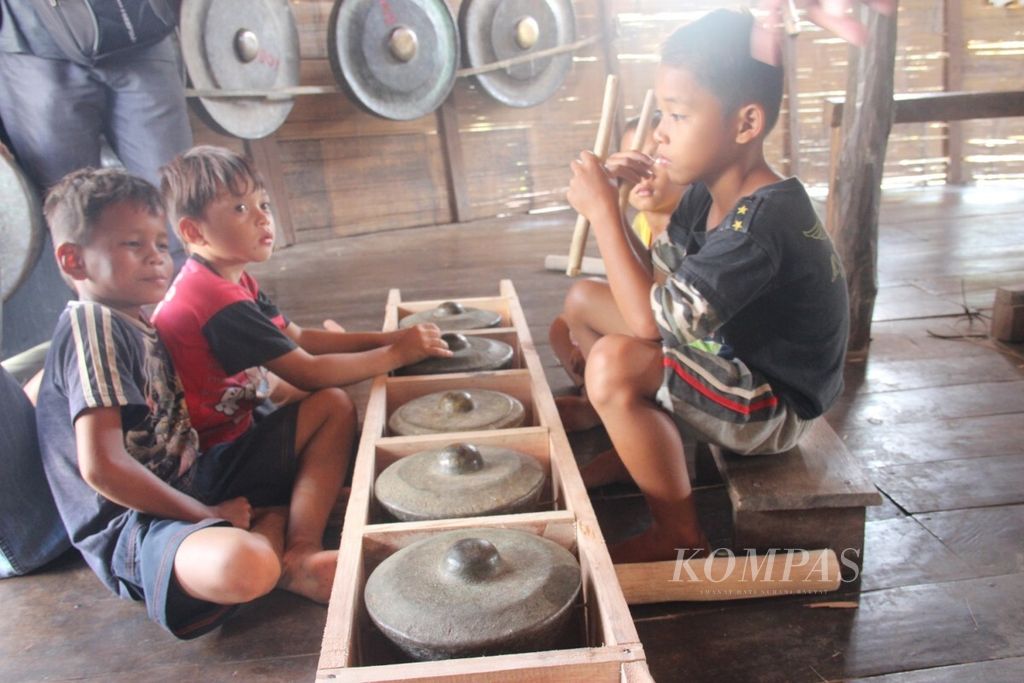 Anak-anak bermain musik di Rumah Balug, rumah adat masyarakat Dayak Bidayuh di Dusun Sebujit, Kabupaten Bengkayang, Kalimantan Barat, Rabu (13/6/2018).