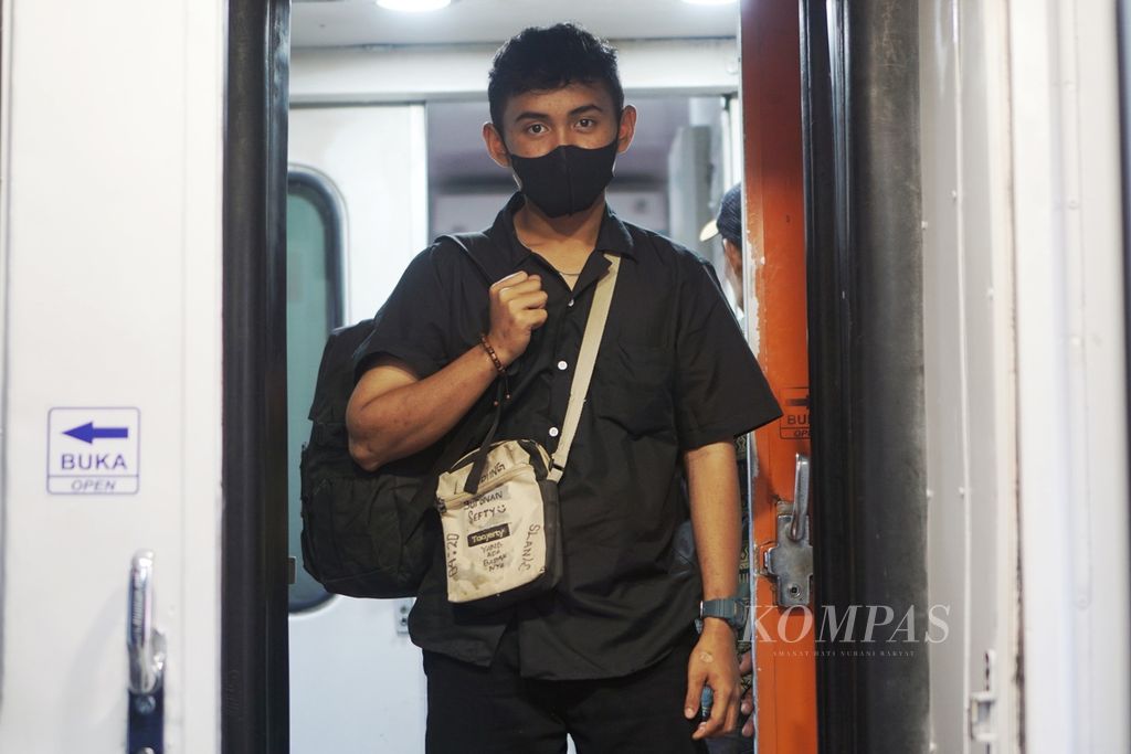 Risky Pratama (22) berpose di pintu kereta relasi Stasiun Rangkasbitung-Stasiun Cilegon, Jumat (5/4/2024). Ia menumpangi kereta menuju Pelabuhan Merak untuk mudik ke Bandar Lampung, Lampung.