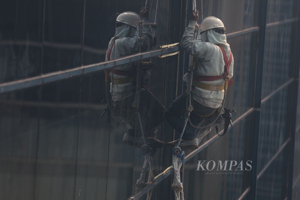 Pekerja bergelantungan melakukan perawatan gedung di kawasan Kuningan, Jakarta, Kamis (12/10/2023). Sesuai laporan tahunan Badan Penyelenggara Jaminan Sosial (BPJS) Ketenagakerjaan, pada 2020 terdapat 221.740 kasus angka kecelakaan kerja. Berikutnya, pada 2021 terdapat 234.370 kasus. Adapun sepanjang Januari-November 2022 tercatat 265.334 kasus. 