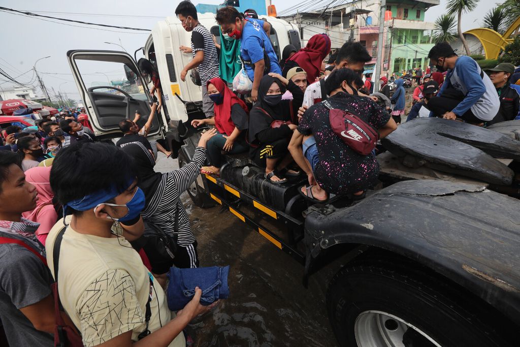 Puluhan warga menumpang truk kontainer untuk menembus banjir rob yang merendam Pelabuhan Perikanan Samudera Nizam Zachman, Muara Baru, Penjaringan, Jakarta Utara, Jumat (5/6/2020).