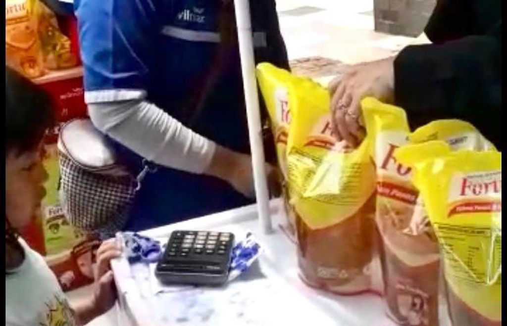 Seorang anak ikut orangtuanya membeli minyak goreng dalam operasi pasar minyak goreng yang digelar Pemprov Sulsel bekerja sama dengan Perum Bulog Divre Sulselbar di Makassar, Selasa (8/3/2022).