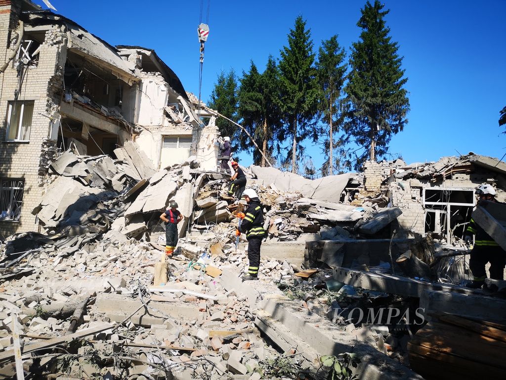 Petugas mengangkat puing-puing reruntuhan sekolah dasar yang hancur terkena rudal di Distrik Shevchenkivskiy Kharkiv, Ukraina, Senin (4/7/2022). Sekolah ini dibom pada Senin pukul 04.00 waktu setempat. Belum diketahui ada tidaknya korban jiwa.