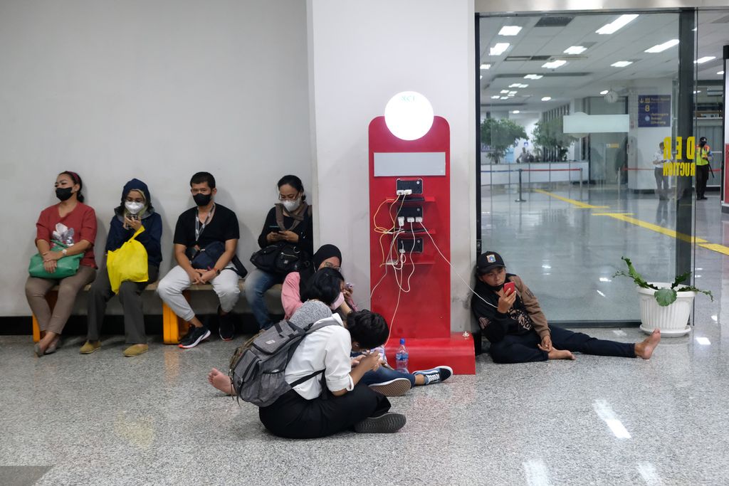 Seorang warga tidak menggunakan masker saat mengisi daya gawai di Stasiun Manggarai, Jakarta Selatan, Jumat (4/11/2022). 