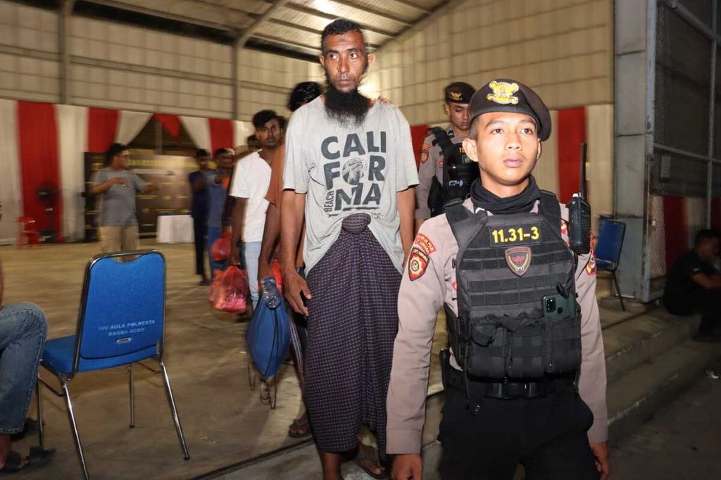 Pengungsi Rohingya dijaga ketat oleh aparat kepolisian saat ditangkap pada Selasa (21/3/2023) malam. Mereka kabur dari kamp penampungan dan diduga hendak masuk ke Malaysia.