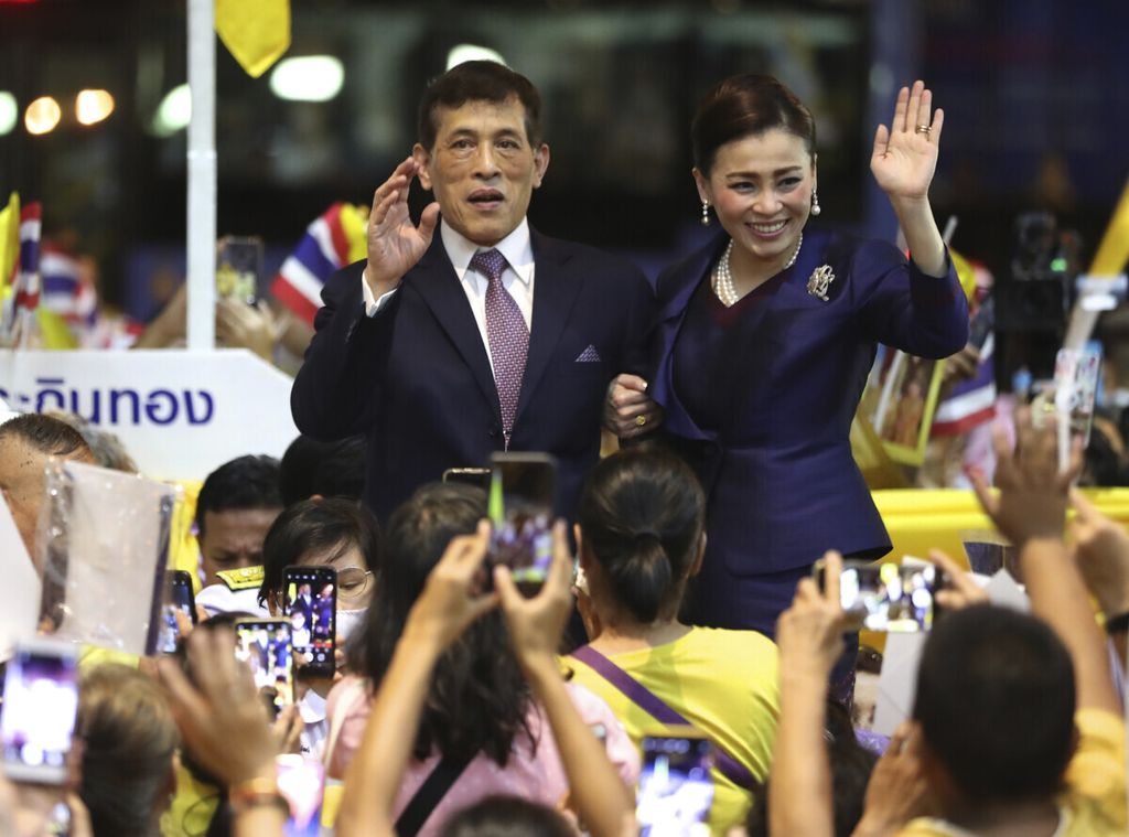 Raja Thailand Maha Vajiralongkorn (kiri) dan Permaisuri Suthida melambaikan tangan ke arah pendukung mereka seusai menghadiri acara pembukaan sebuah stasiun kereta baru di Bangkok, Thailand, 14 November 2020. 