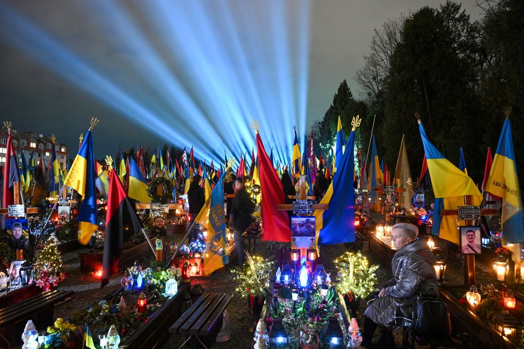Iluminasi simbolis yang disebut "Sinar Kenangan" terlihat, Jumat (23/2/2024), di Pemakaman Lychakiv, kuburan tentara Ukraina yang tewas dalam perang melawan Rusia, di Lviv, Ukraina barat.  