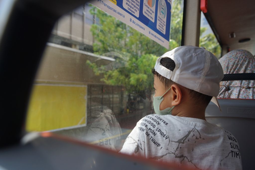 Warga Pamulang, Tangerang Selatan, Arsaka, menatap ke luar jendela dalam bus wisata Transjakarta atau bus Jakarta Explorer, Minggu (23/4/2023).