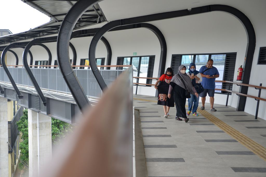 Sejumlah warga berjalan di jembatan layang penyeberangan orang simpang temu di Stasiun MRT Lebak Bulus, Lebak Bulus, Jakarta Selatan, Jumat (30/12/2022). 