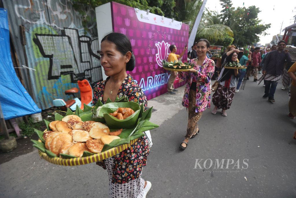 Warga mengusung kue apem saat mengikuti kirab ruwahan dalam Sarkemfest atau Festival Sarkem 2024 di Jalan Sosrowijayan, Yogyakarta, Jumat (1/3/2024).