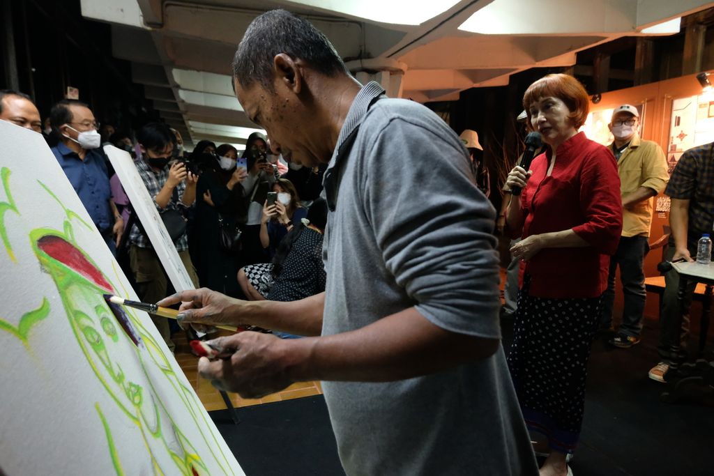 Dwi Putro (kiri) melukis pengunjung dalam pembukaan pameran di Bentara Budaya Jakarta, Palmerah, Jakarta, Rabu (12/10/2022). 