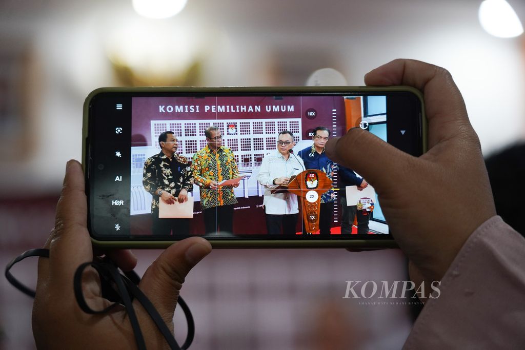 Seorang jurnalis menggunakan gawainya untuk memotret konferensi pers terkait Pembentukan Badan Ad Hoc Penyelenggara Pemilu Tahun 2024 untuk Panitia Pemilihan Kecamatan (PPK) dan Panitia Pemungutan Suara (PPS) di Kantor Komisi Pemilihan Umum (KPU), Jakarta, Kamis (17/11/2022). 