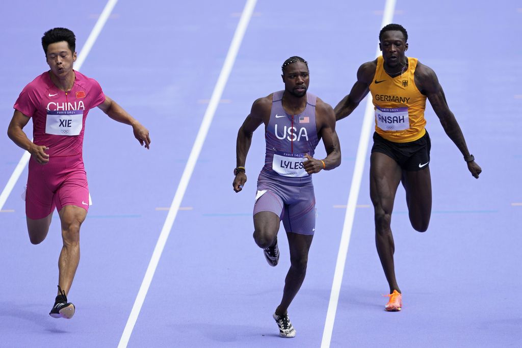 Sprinter Amerika Serikat, Noah Lyles (tengah), berlari pada babak <i>heat</i> pertama nomor 100 meter Olimpiade Paris 2024 di Saint-Denis, Paris, Perancis, Sabtu (3/8/2024). 