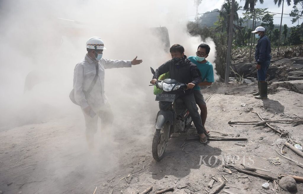 Warga melewati debu saat menyelamatkan barang dari rumahnya yang rusak oleh material awan panas guguran di Dusun Kajar Kuning, Desa Sumberwuluh, Kecamatan Candipuro, Kabupaten Lumajang, Jatim, Selasa (6/12/2022). Warga yang rumahnya terdampak kini fokus pada penyelamatan barang-barang yang masih bisa diselamatkan. 