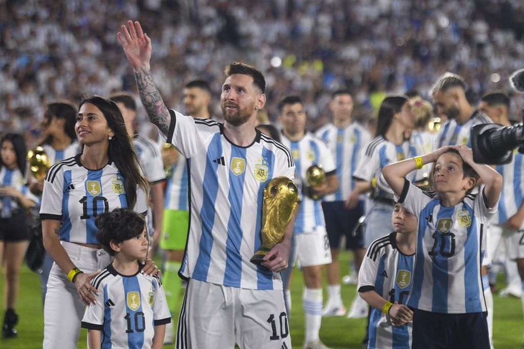 Pemain Argentina, Lionel Messi, berjalan mengelilingi Stadion Monumental di Buenos Aires bersama istri dan anak-anaknya sambil membawa replika Piala Dunia pada perayaan juara Piala Dunia seusai laga persahabatan melawan Panama, Jumat (24/3/2023). 