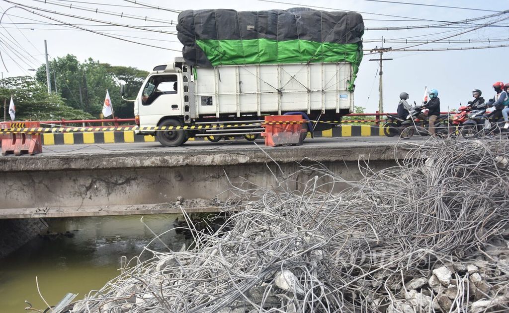 Truk melintasi ruas jalan tersisa dari Jembatan Ngaglik 1 yang ambles dan sedang dalam proses penghancuran di Kabupaten Lamongan, Jawa Timur, Rabu (30/3/2022). 