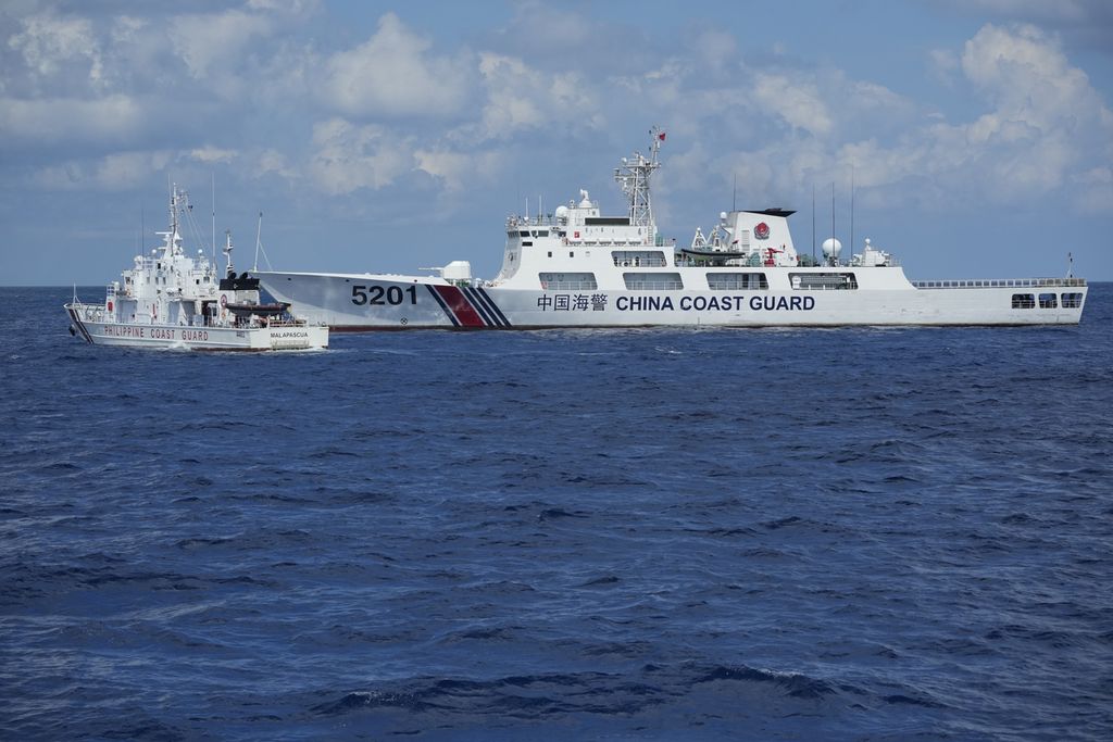 Kapal penjaga pantai Filipina BRP Malapascua (kiri) bermanuver keluar setelah kapal penjaga pantai China dengan haluan nomor 5201 mencoba memasuki wilayah Laut China Selatan, Minggu (23/4/2023). 