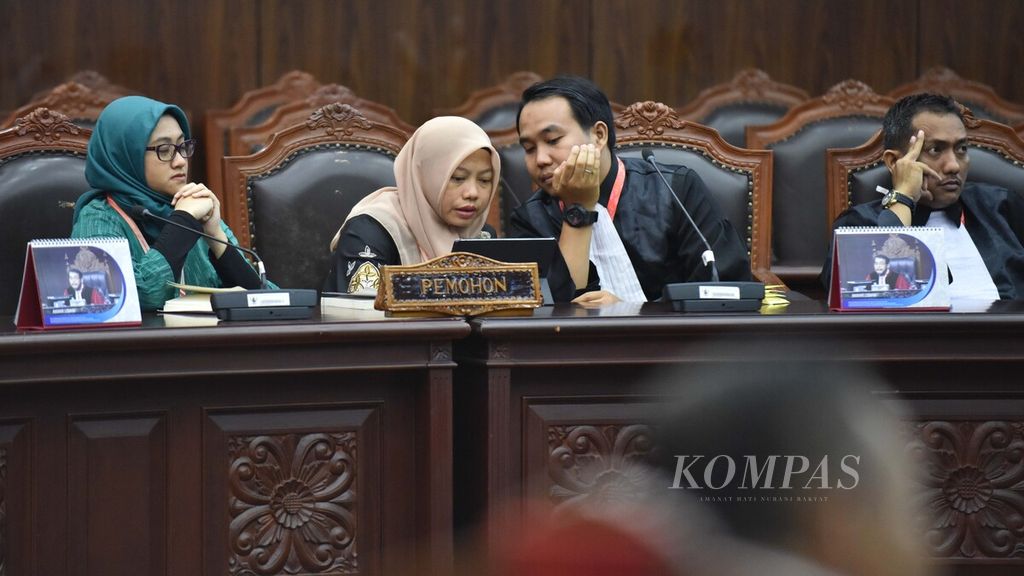Direktur Eksekutif Perkumpulan untuk Pemilu dan Demokrasi ( Perludem) Titi Anggraini (kedua dari kiri) berbincang dengan kuasa hukumnya, Fadli Ramadhanil, saat mengikuti sidang putusan uji materi Undang-Undang Nomor 7 Tahun 2017 tentang Pemilu dan Undang-Undang Nomor 10 Tahun 2016 tentang Pemilihan Gubernur, Bupati, dan Wali Kota Menjadi Undang-Undang (Pilkada) di Gedung Mahkamah Konstitusi (MK) Jakarta, Rabu (26/2/2019).