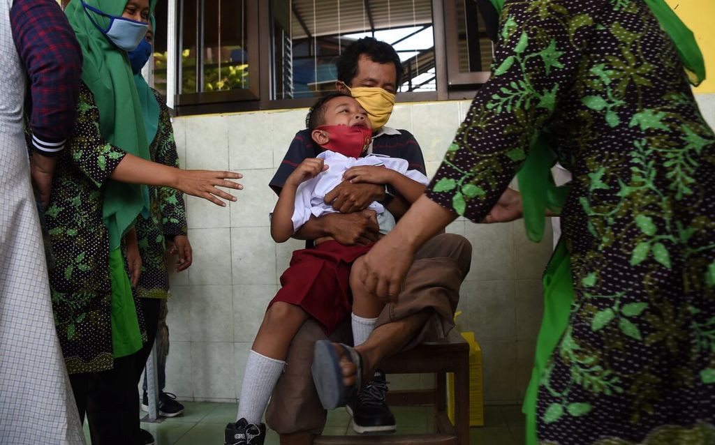 Siswa menangis saat diimunisasi pada hari kedua pelaksanaan Bulan Imunisasi Anak Sekolah di SD Negeri Kaliasin V Surabaya, Jawa Timur, Kamis (15/10/2020).  Pandemi Covid-19 membuat program imunisasi dasar  pada anak terkendala.