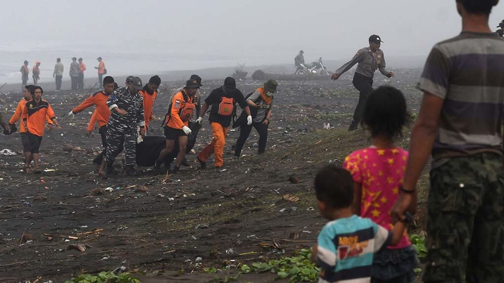 Ilustrasi. Warga menyaksikan tim Basarnas mengangkut jenazah korban kapal tenggelam yang ditemukan di bibir pantai di perairan Plawangan Puger, Jember, Jawa Timur, Jumat (20/7/2018).