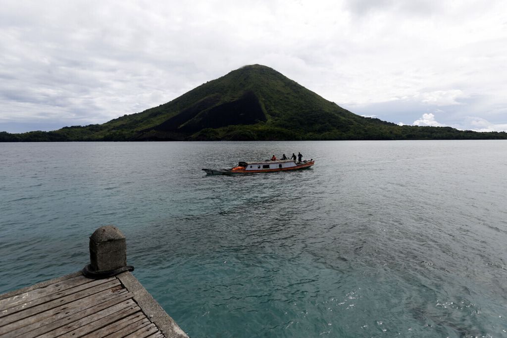 Perahu hendak merapat di dermaga perkampungan Lonthoir, Pulau Banda Besar, Kepulauan Banda, Maluku, dengan latar belakang Pulau gunung Api, Rabu (26/4/2017).  