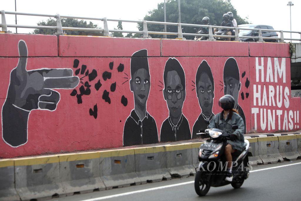 Mural berisi tuntutan untuk penuntasan kasus pelanggaran HAM menghiasi Jembatan Layang Grogol di depan Kampus Universitas Trisakti, Jakarta, Kamis (28/7/2022). Saat ini, Mahkamah Agung meloloskan delapan nama calon hakim <i>ad hoc </i>pelanggaran HAM berat Paniai, Papua. 