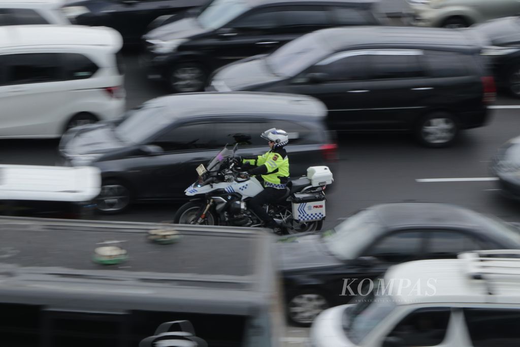 Polisi melintas di tengah padat arus kendaraan di Tol Jakarta-Cikampek km 72 arah Jakarta pada Minggu (14/04/2024).