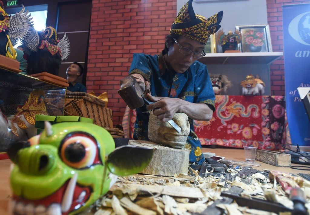 Perajin tunadaksa Mustaqbilal membuat patung di stan Dinas Sosial Jawa Timur dalam Pameran Akbar Jatim Fair 2019 di Grand City Surabaya, Jawa Timur, Selasa (8/10/2019). 