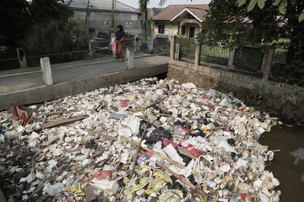 Sampah plastik menumpuk di saluran Kali Baru, Ratu Jaya, Depok, Jawa Barat, Senin (19/8/2019). Sampah plastik yang sebagian kiriman dari Bogor ini menutupi permukaan saluran air. Rendahnya tingkat kesadaran warga dalam menjaga lingkungan dapat berdampak pada menurunnya kualitas hidup masyarakat. Kompas/Hendra A Setyawan (HAS)19-8-2019