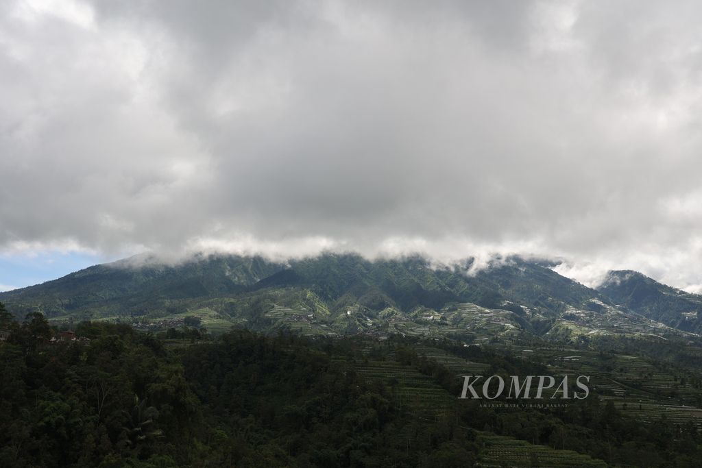 Awan menggelayut di atas lahan pertanian di kaki Gunung Merbabu, Magelang, Jawa Tengah, Senin (10/4/2023).