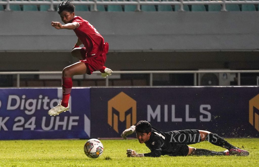 Striker Indonesia, Arkhan Kaka Putra (atas), melewati kiper Guam, Jacob Anthony Toves (bawah), dalam laga sepak bola kualifikasi Piala Asia U-17 2023 di Stadion Pakansari, Kabupaten Bogor, Jawa Barat, Senin (3/10/2022). Indonesia menang telak, 14-0. 