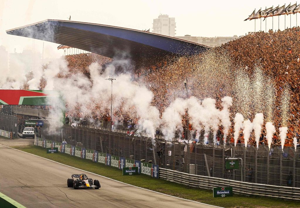 Pebalap Red Bull Max Verstappen disambut kembang api sebagai pebalap pertama melewati garis finis dalam balapan Grand Prix Formula 1 seri Belanda di Sirkuit Zandvoort, Belanda, Minggu (4/9/2022). 