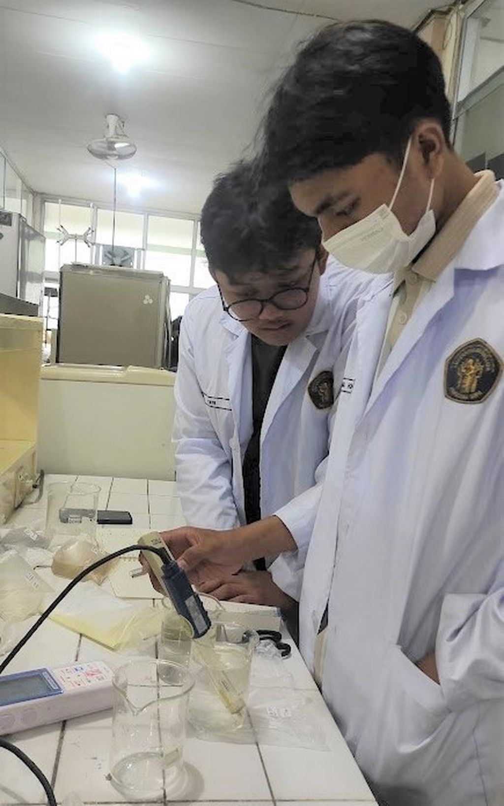 Raditya Syarifatur Riyad (kiri) dan Raffi Radithya Risqullah (kanan) ketika menguji sampel air di laboratorium.