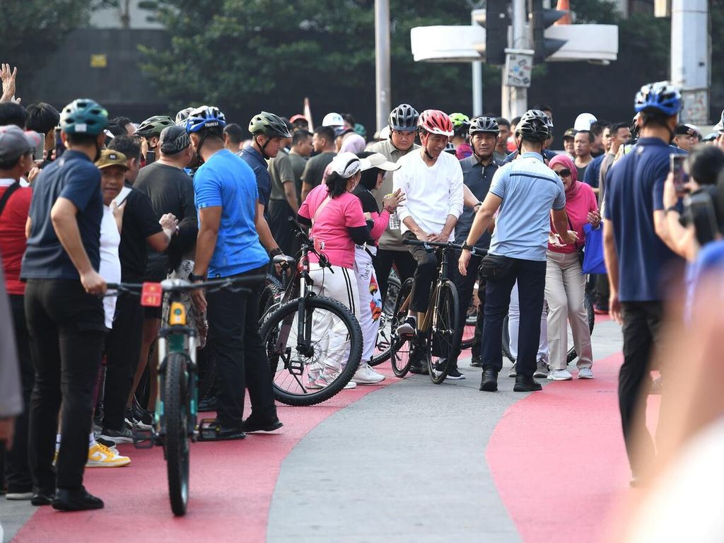 Presiden Joko Widodo bersepeda pagi di kawasan Jalan Thamrin Sudirman, Jakarta, Minggu (5/5/2024). Aktivitas ini dimanfaatkan warga yang kebetulan joging untuk berfoto bersama.