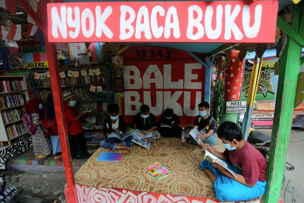 Anak-anak membaca buku di Bale Buku di perkampungan Gang Dendrit, RT 004 RW 008, Kecamatan Cakung, Jakarta Timur, Senin (29/11/2021). Bale ini berawal dari pos ronda yang disulap menjadi perpustakaan untuk anak-anak. 