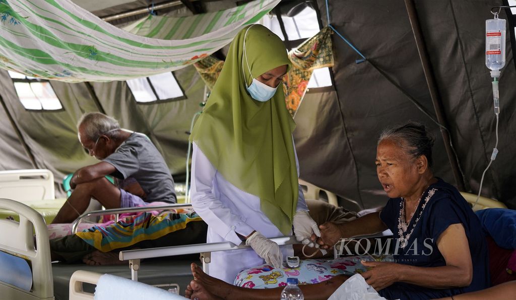 Perawat memeriksa kesehatan pasien yang dirawat di tenda darurat di halaman Rumah Sakit Islam Ibnu Sina, Simpang Empat, Pasaman Barat, Sumatera Barat, Selasa (1/3/2022). Mereka yang dirawat ini adalah pasien rawat inap dan pasien korban gempa pada 25 Februari 2022 lalu. 