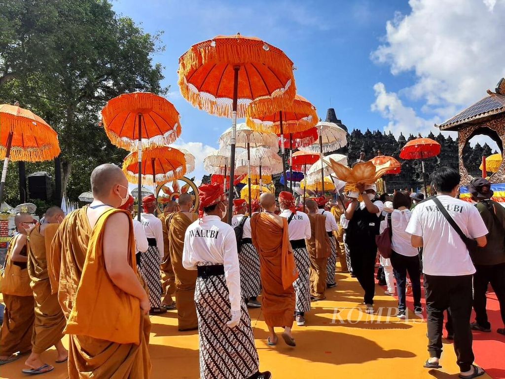 Umat bersama biksu beramai-ramai memasuki area perayaan Trisuci Waisak 2566 BE/2022 di pelataran Candi Borobudur, Kabupaten Magelang, Jawa Tengah, Senin (16/5/2022).