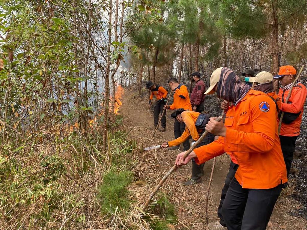 Petugas berupaya membuat ilaran untuk mencegah kobaran api meluas, Senin (2/10/2023). Kebakaran hutan dan lahan di kawasan Gunung Lawu, Kabupaten Ngawi, Jawa Timur, secara kumulatif mencapai 1.100 hektar.