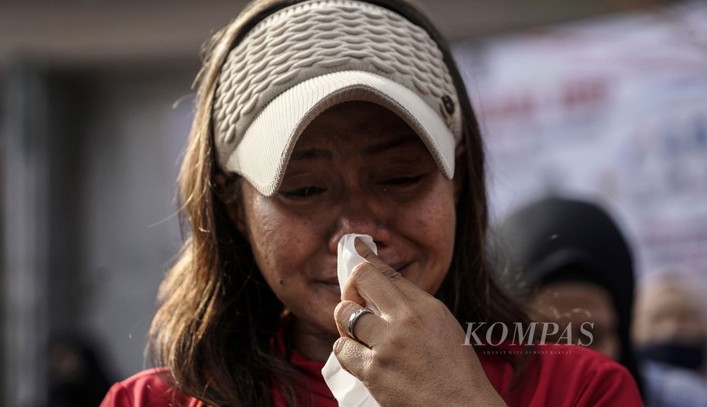 Seorang ibu menangis haru ketika melihat anaknya membasuh kakinya dalam aksi Cuci Kaki Ibu Massal di Jalan Suryo Pranoto, Petojo, Jakarta, Minggu (18/12/2022). 